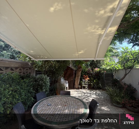 מרפסת עם שולחן וכיסאות תחת סוכך